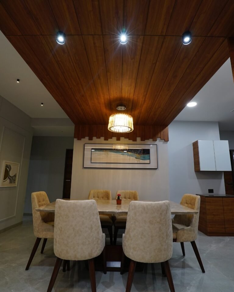 “Elegant Dining Area with Wooden False Ceiling & Ambient Lighting”